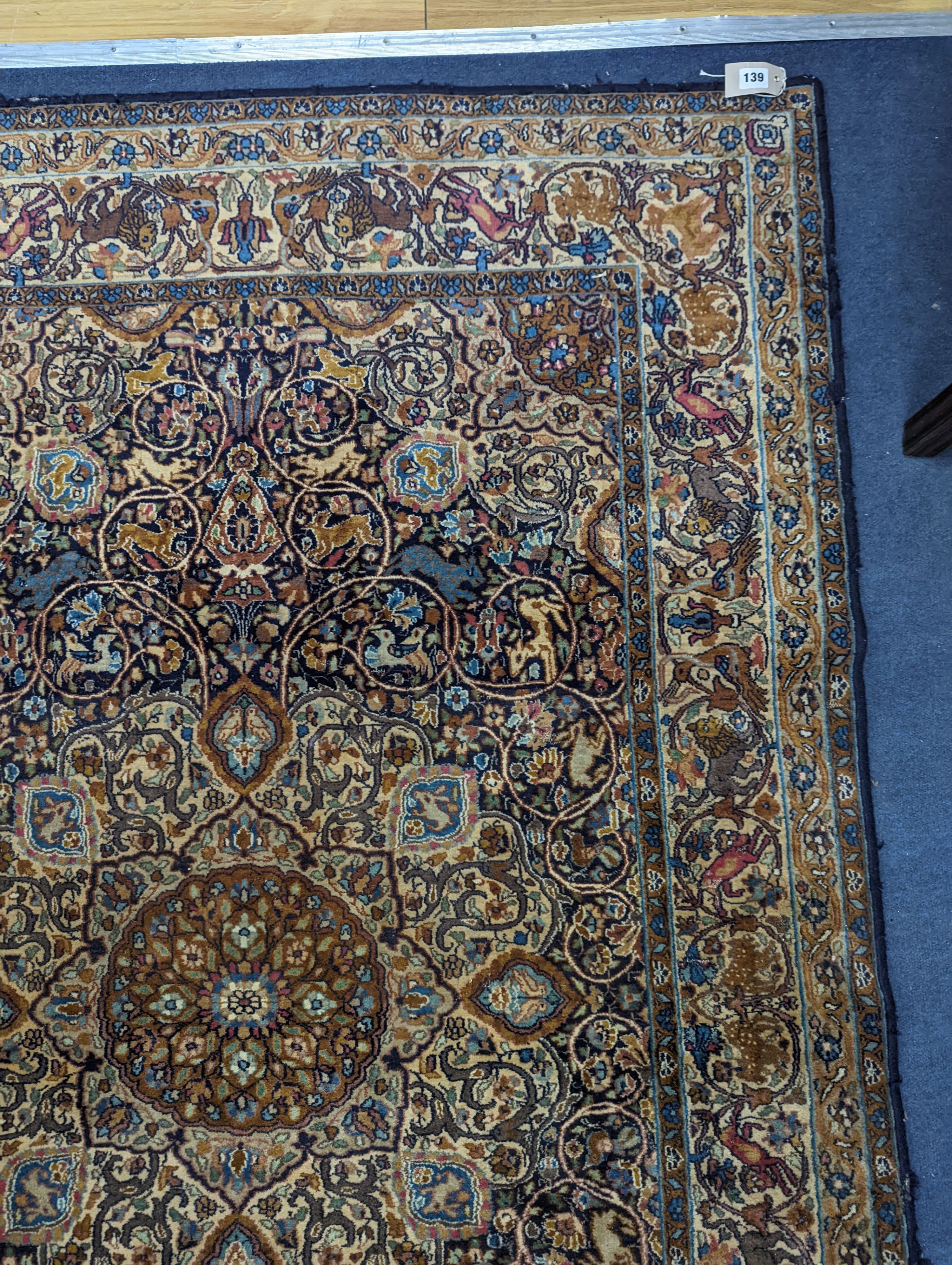 A Kashan blue ground rug woven with animals. 187x125cm.